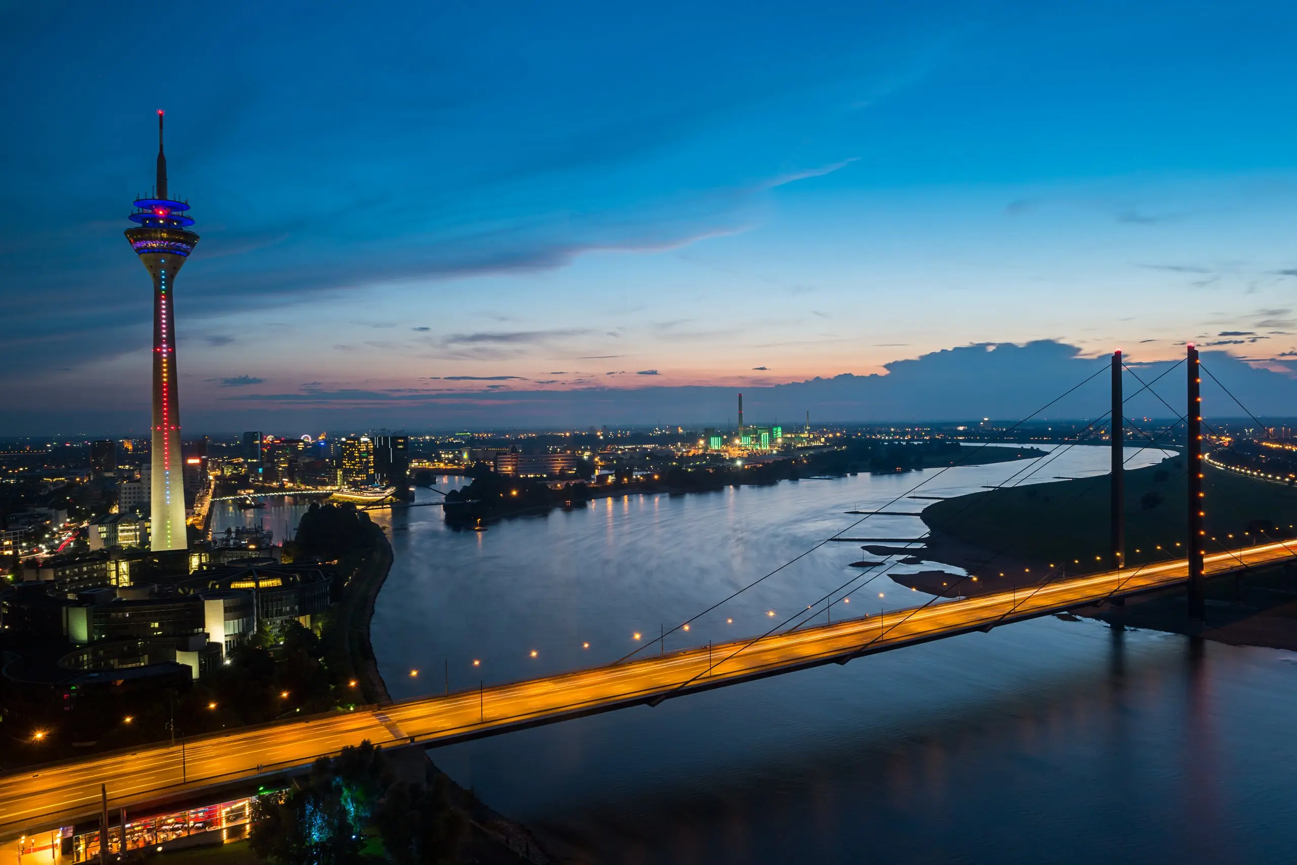 The Rhine in Düsseldorf in the evening, with the Rhine Tower and the Rheinknie Bridge